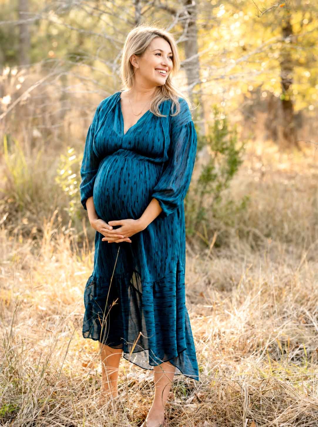 Kreativ personlig gravid fotografering i skoven på en sommerdag